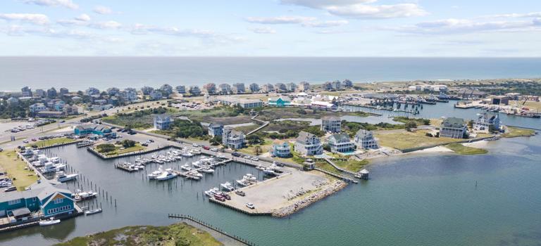 Drone view of Teach's Lair Marina from over the sound. Hatteras Landing, the ferry docks, and the ocean in the distance.