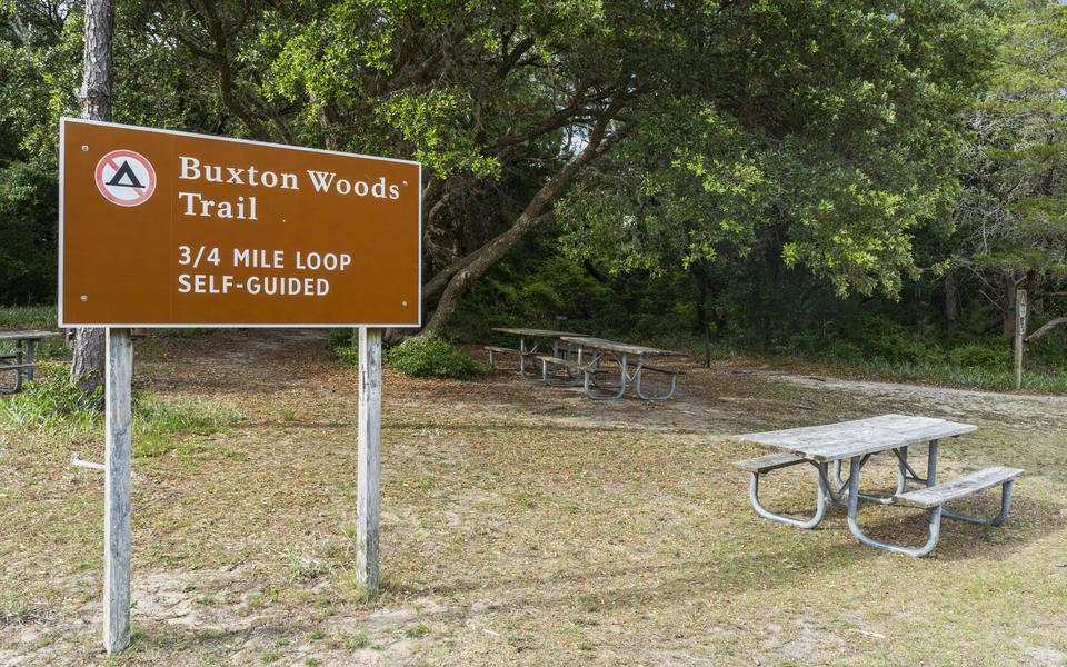 Sign to the 3/4 mile loop of Buxton Woods Trail for hiking showing a picnic table