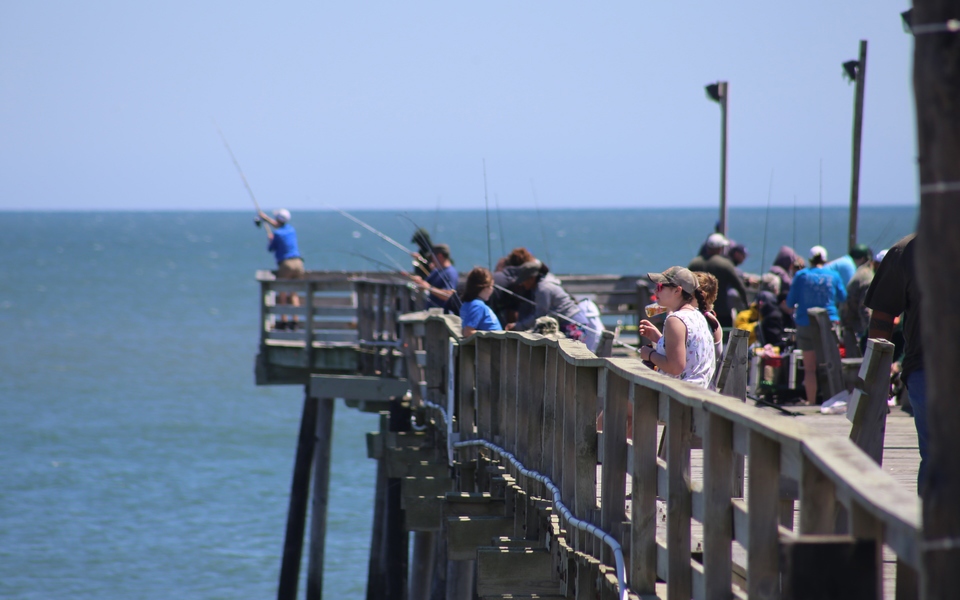 Sightseers and people fishing in a zoomed in (long lens) shot of the end of the Rodanthe Fishing Pier