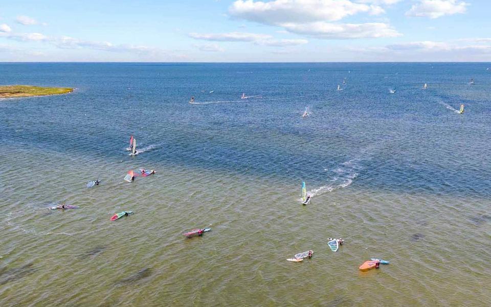 Dozens of windsurfers dot the sound in this aerial drone shot looking out over the Pamilco Sound from Avon