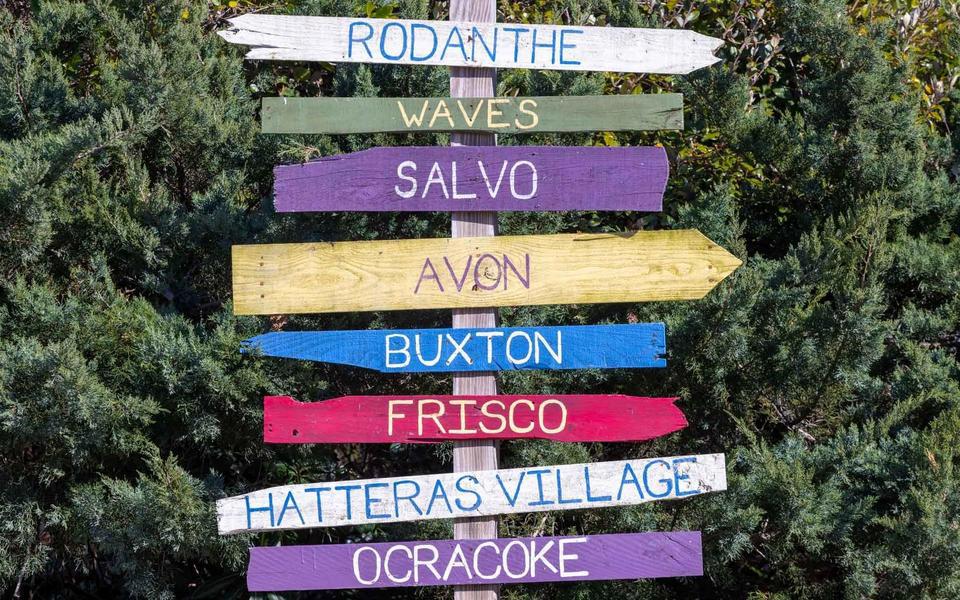 Colorful wayfinding signs pointing to Rodanthe, Waves, Salvo, Avon, Buxton, Frisco, Hatteras Village, and Ocracoke
