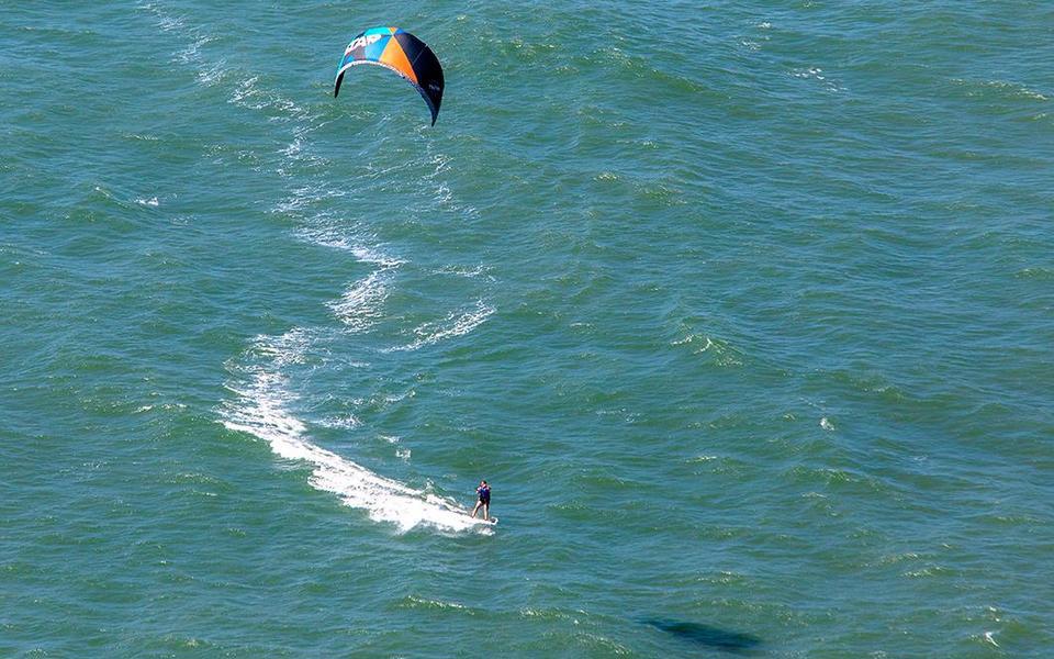 High angle drone view of a kiteboarder and their kite from above looking down on the sound