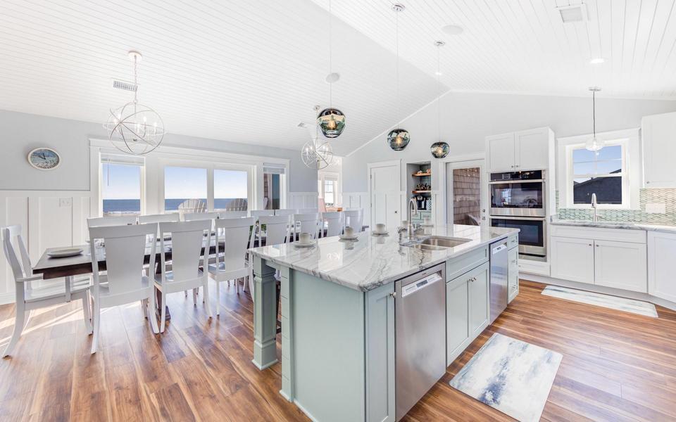 Beautiful modern kitchen and dining area in one of the vacation homes we market here at Surf or Sound Realty