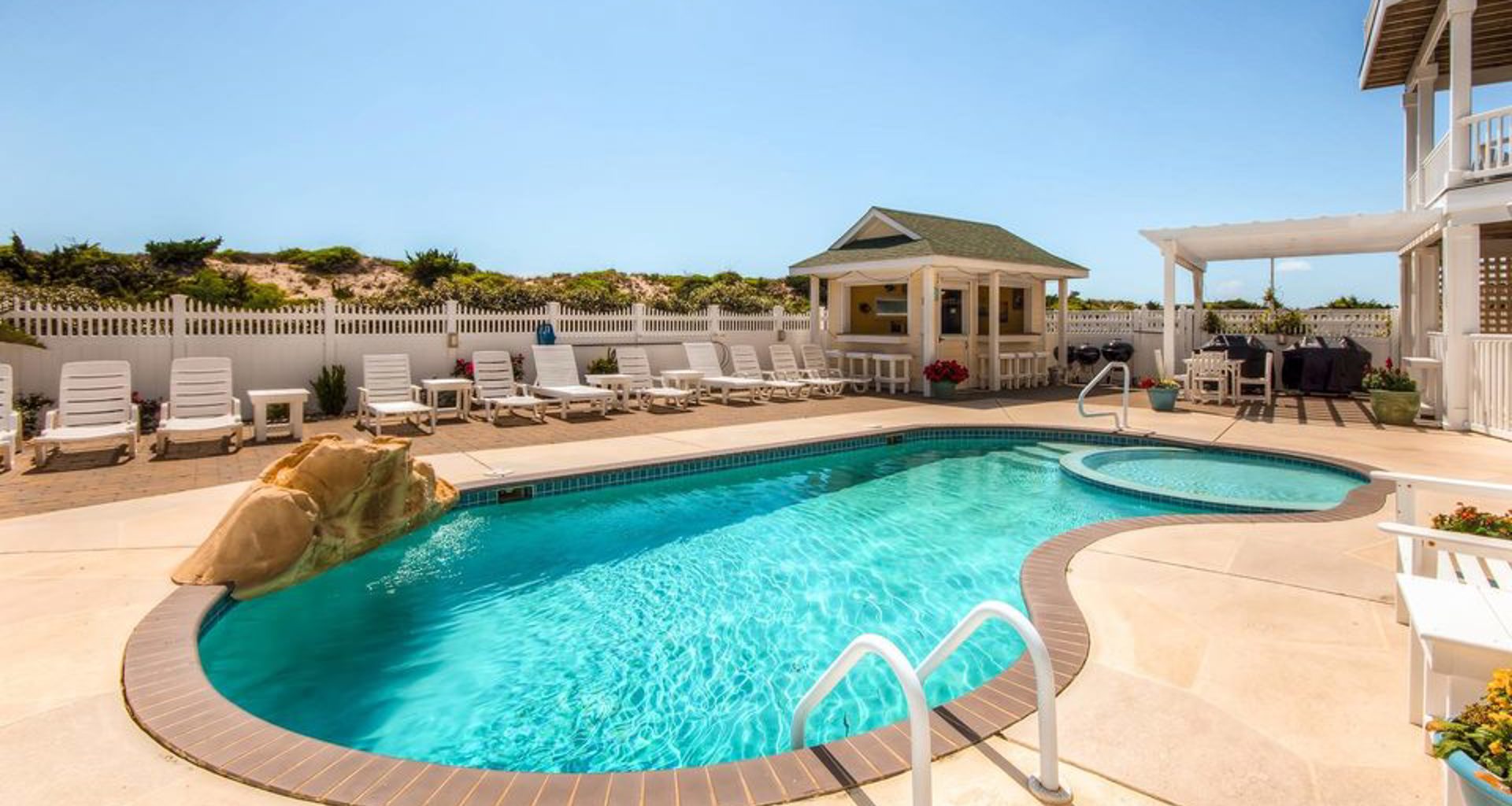 Bright aqua blue water shimmers in a vacation home private pool in the summer under blue skies on Hatteras Island