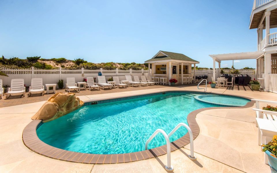 Bright aqua blue water shimmers in a vacation home private pool in the summer under blue skies on Hatteras Island