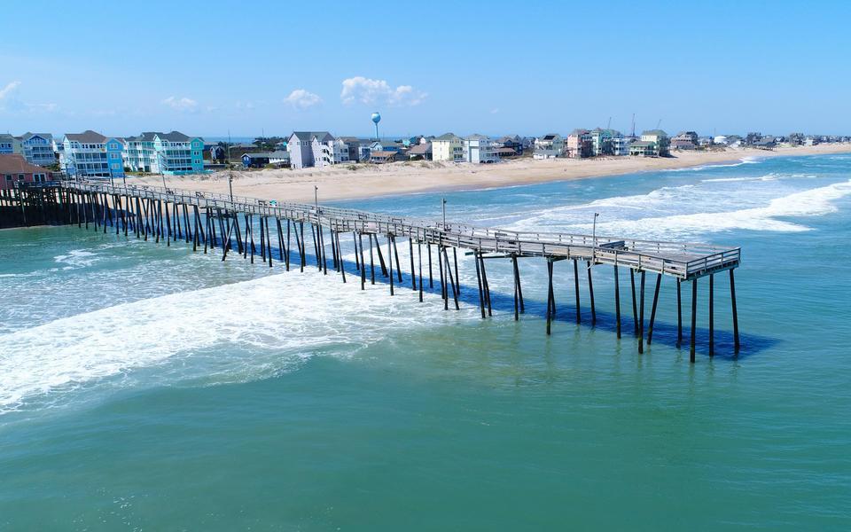 Drone shot of the Rodanthe Pier from the SW over the Atlantic Ocean looking NE showing vacation homes along the beach