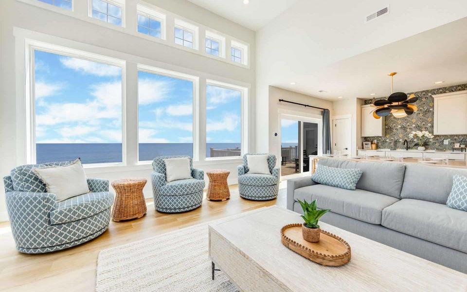 Blue skies and white clouds outside big picture windows of a luxury waterfront vacation home on Hatteras Island