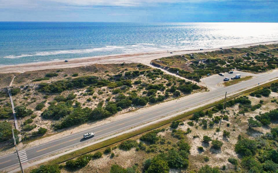 Route 12, a public beach access, an ORV ramp, and the ocean seen from a drone near Avon, NC