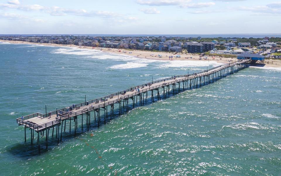 The Avon Fishing Pier as seen from a drone over the ocean looking SW toward vacation homes along the beach